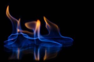 Captivating image of vibrant blue and orange flames dancing on a dark surface.