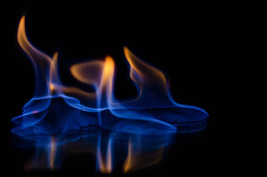 Captivating image of vibrant blue and orange flames dancing on a dark surface.