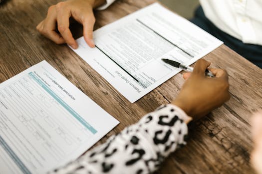 What Is EcoVadis – And Why It Matters For Your Business Close-up of two people reviewing and filling out a credit card application on a wooden table.